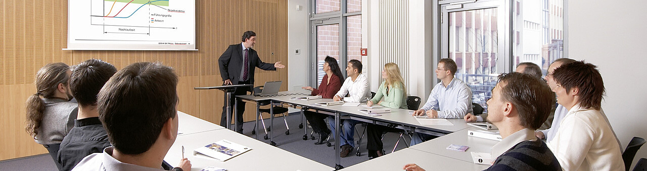 Man gives a lecture to participants in a conference room