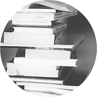 Black and white image of books stacked on top of each other